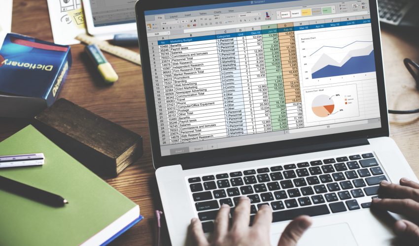 Closeup of hands using computer laptop with screen showing analysis data